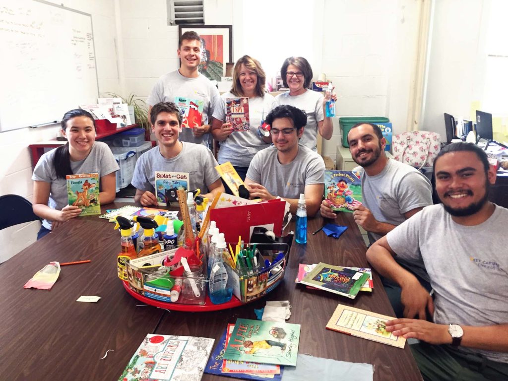 Group of employees with children's books.