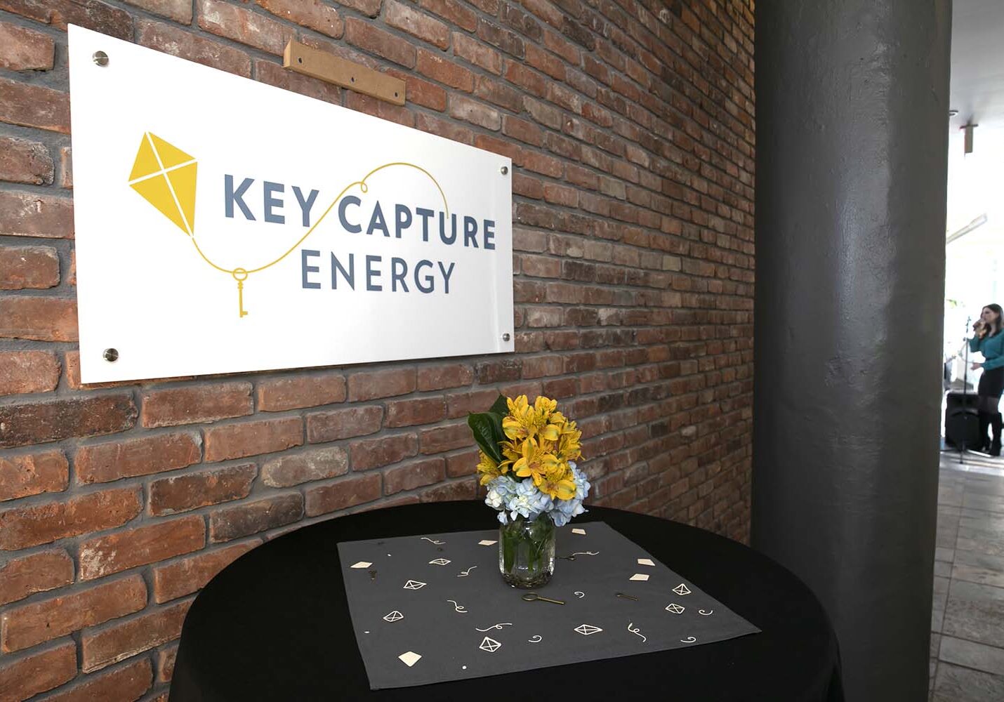 Sign with the Key Capture Energy logo on it on a brick wall.