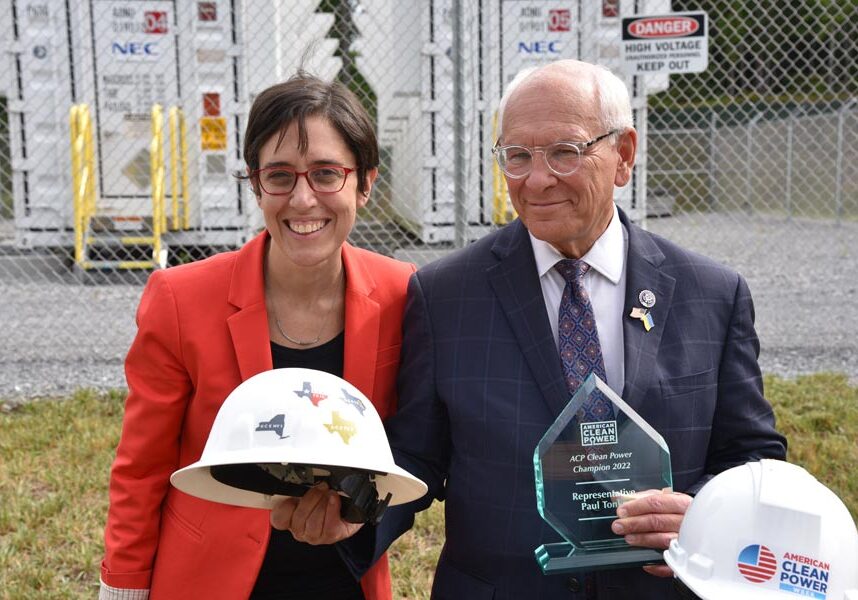 Man and woman holding a hard hat and an award.